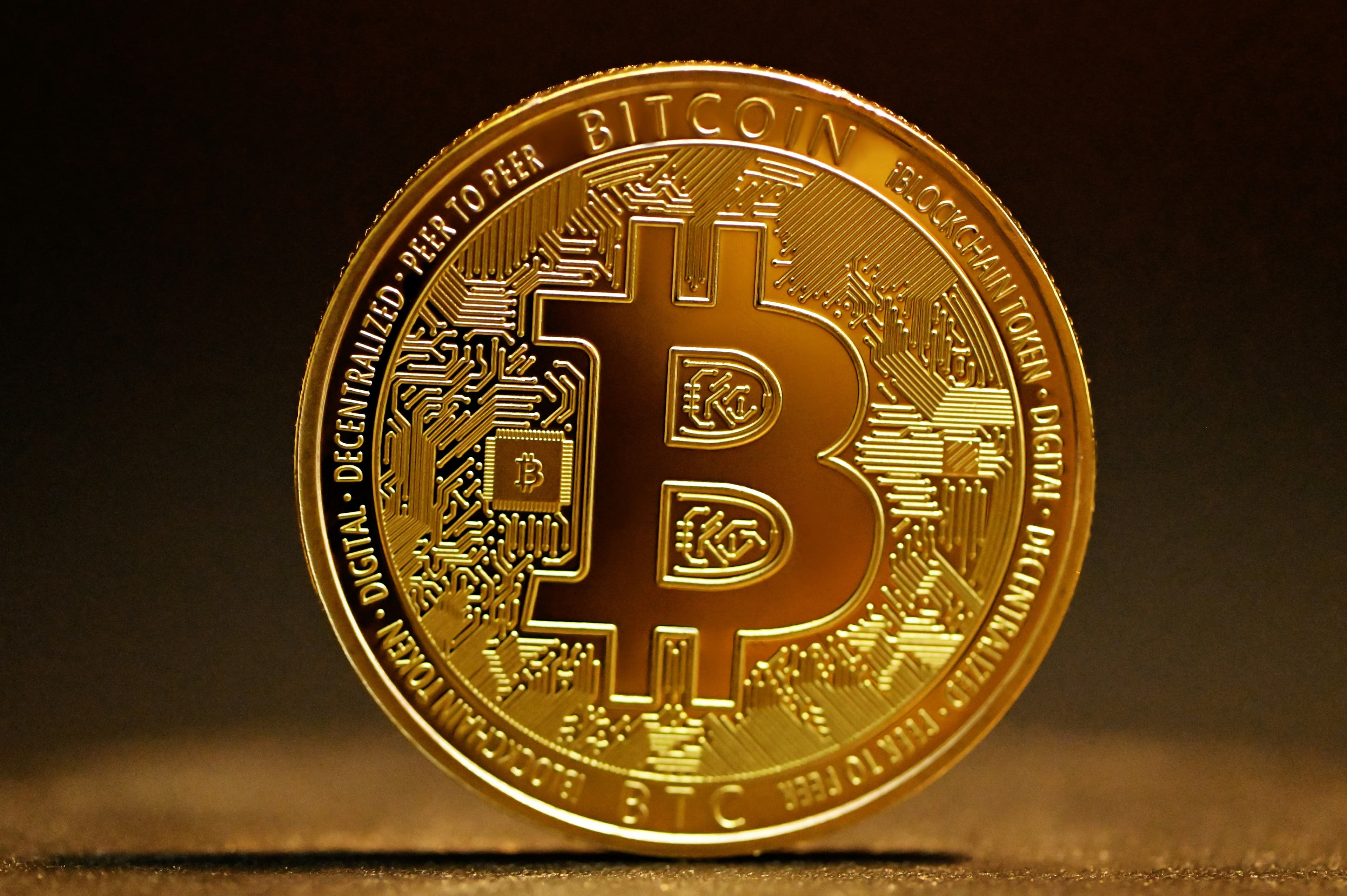 Eine physische Goldmünze mit dem Bitcoin-Logo.
